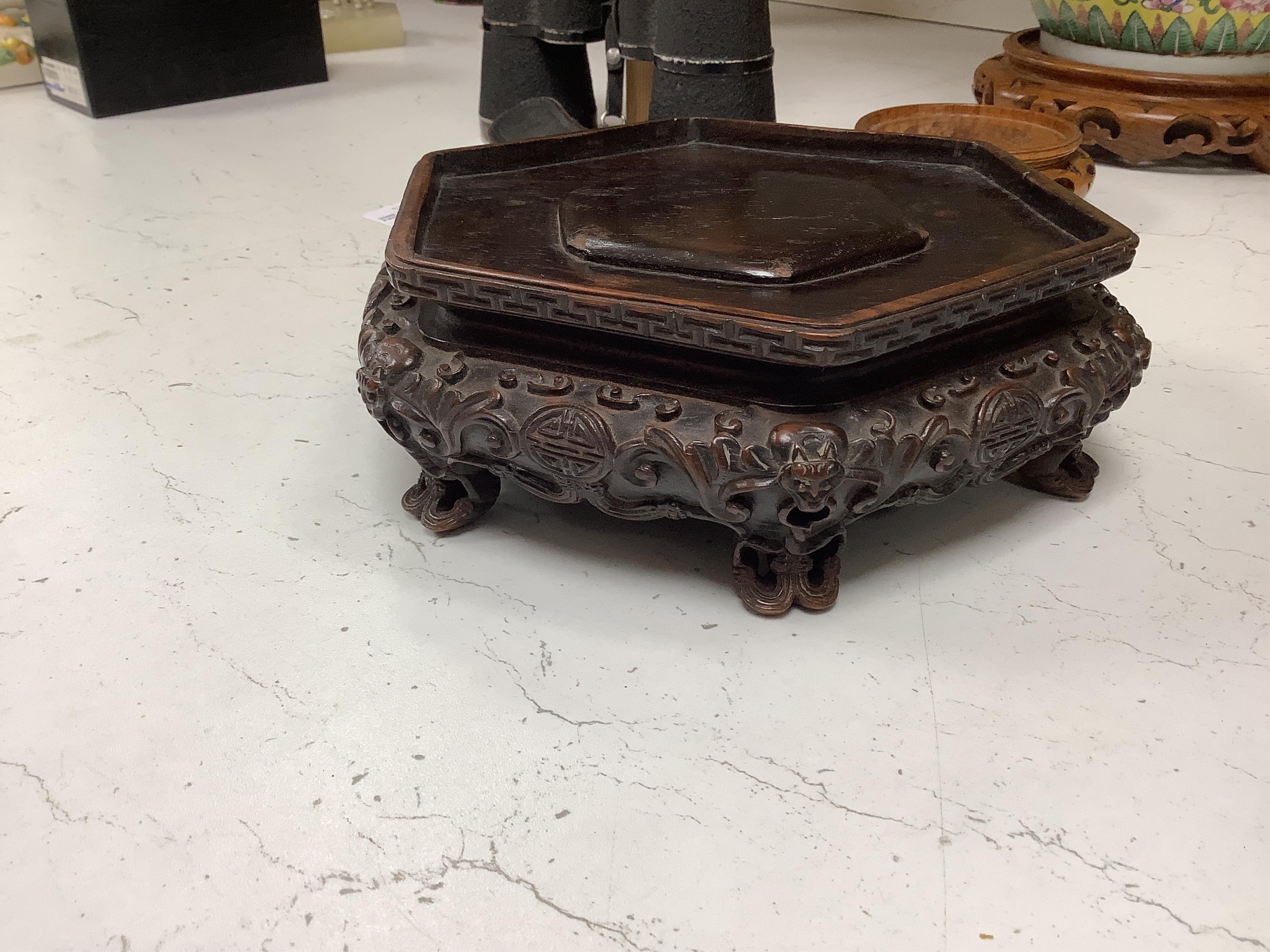 A Chinese famille rose vase and cover, late 19th century, together with a good carved hongmu ‘bats and shou’ stand, vase 36cm. Condition - crack to rim